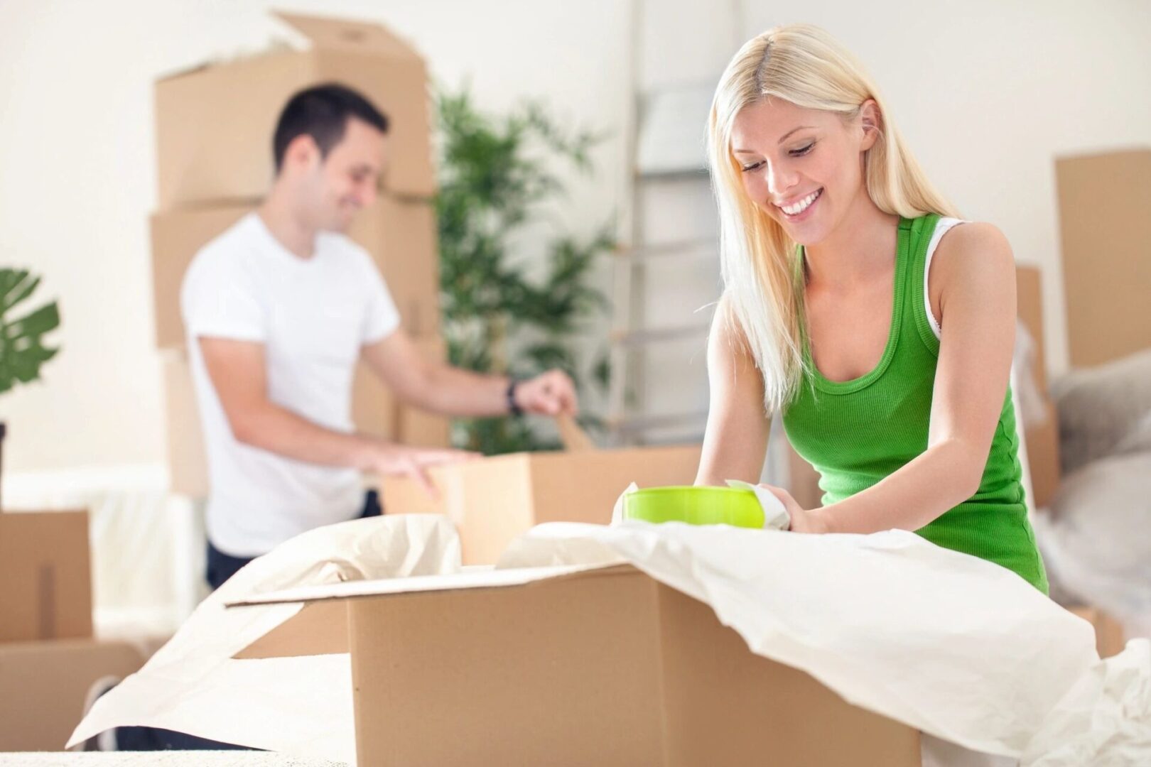 Young couple unpacking moving boxes in a living room